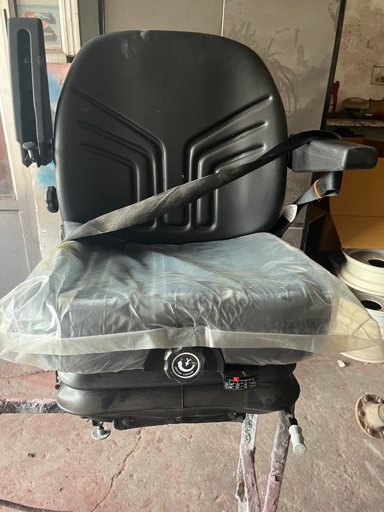 Black adjustable weight-adjust tractor seat with armrest